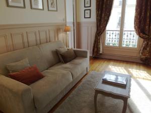 a living room with a couch and a coffee table at Chambre d hôte : Louvre Elegant Apt Suite in Paris