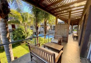 un patio con panchine, recinzione e alberi di Altos de la Serena Apart Hotel a La Paloma