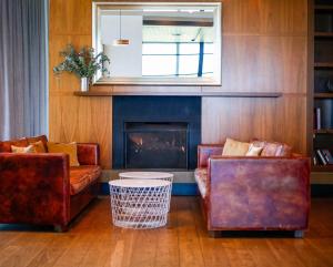 a living room with two couches and a fireplace at The Sands Torquay in Torquay