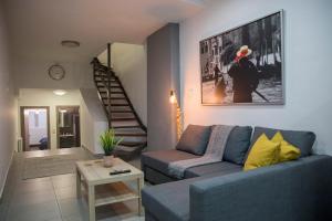 a living room with a blue couch and a staircase at BILLYS HOUSE in Tríkala