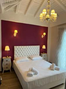 una camera da letto con un grande letto bianco con una parete rossa di Theokleia_guest house a Kavala