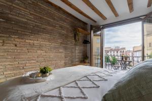 una camera da letto con un muro di mattoni e un letto di Cathedral Suite Home a Logroño