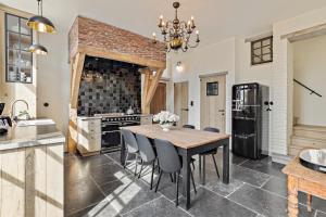 a kitchen with a table and chairs and a refrigerator at Huis Potaerde, luxe villa, vakantiewoning - landhuis nabij Brussel in Merchtem