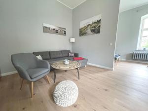 uma sala de estar com um sofá e uma mesa em Gästehaus Sternschanze - App2 Kapitänleutnant em Stralsund