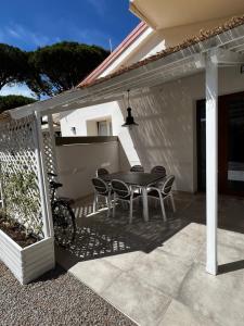 un patio con tavolo e sedie su una casa di Punta Ala - Tra mare e natura a Punta Ala