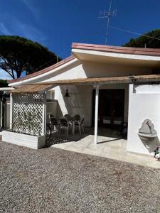 una casa bianca con sedie e un patio di Punta Ala - Tra mare e natura a Punta Ala