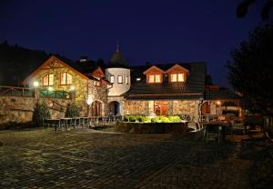 ein großes Haus in der Nacht mit eingeschaltetem Licht in der Unterkunft Zámeček Kaliště in Poddubí