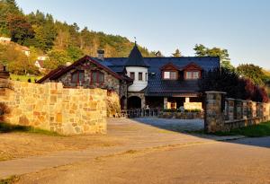 ein Haus mit einem Steinzaun davor in der Unterkunft Zámeček Kaliště in Poddubí