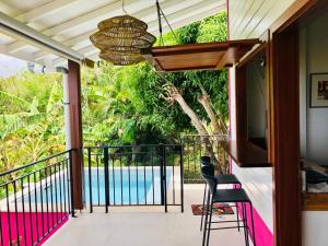 een balkon met uitzicht op een zwembad bij Magnifique Villa Bauhinia, Piscine vue mer in Sainte-Luce