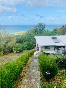 een wit gebouw met de oceaan op de achtergrond bij Magnifique Villa Bauhinia, Piscine vue mer in Sainte-Luce