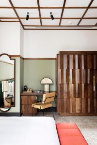 a room with a mirror and a chair and a desk at La Maison Palmier Abidjan, a Member of Design Hotels in Abidjan