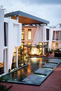 an exterior view of a building with a swimming pool at La Maison Palmier Abidjan, a Member of Design Hotels in Abidjan