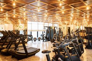 a gym with a lot of treadms and cardio machines at La Maison Palmier Abidjan, a Member of Design Hotels in Abidjan