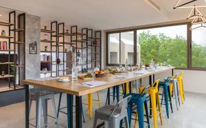 a dining room with a long table and colorful chairs at Campanile El Mechtel Tunis in Tunis