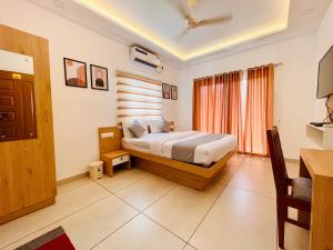 um quarto com uma cama e uma grande janela em Oceana Hills Residency em Alappuzha