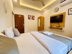 um quarto com uma cama grande e uma televisão de ecrã plano em Oceana Hills Residency em Alappuzha