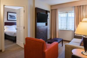 a hotel room with a bed and a living room at Sonesta Chicago O'Hare Airport Rosemont in Rosemont