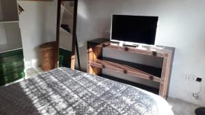 una camera con letto e TV a schermo piatto di La Armonie de Chacras a Chacras de Coria