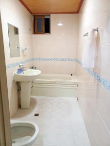 a bathroom with a sink and a toilet and a tub at Myungsung Youth Town in Gyeongju