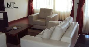 salon z białą kanapą i krzesłem w obiekcie Norfolk Towers Serviced Apartment -Nairobi, City Centre CBD w mieście Nairobi