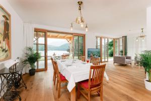 een eetkamer met een witte tafel en stoelen bij Villa Frischmuth am See in Altaussee