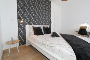 een slaapkamer met een bed met een zwart-wit hoofdeinde bij L'Urbain by EasyEscale in Romilly-sur-Seine