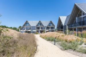 een huis aan het strand met een onverharde weg bij Hotel Zeeuws Licht I Kloeg Collection in Dishoek