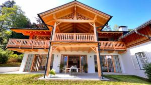 een groot houten huis met een groot terras bij Villa Frischmuth am See in Altaussee