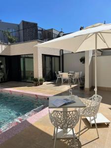 a table and chairs with an umbrella next to a pool at ABC Hotel in Blankenberge