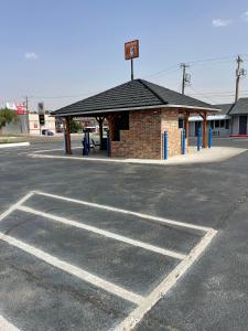 um parque de estacionamento vazio em frente a uma bomba de gasolina em Buffalo Inn Vintage MOTEL em Canyon