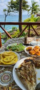 a table with plates of food on top of it at Gombela Ecolodge and Farming in São Tomé