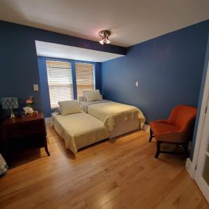 um quarto azul com uma cama e uma cadeira em Garden 2 Storey House em Cataratas do Niágara