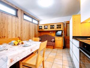 uma sala de jantar com uma mesa e uma cozinha em Apartment Cincelli - Catinaccio by Interhome em Pozza di Fassa