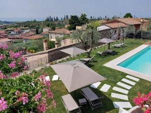 une terrasse avec un parasol et une piscine dans l'établissement Il cantuccio sul Garda - Relais di charme, à Cavaion Veronese