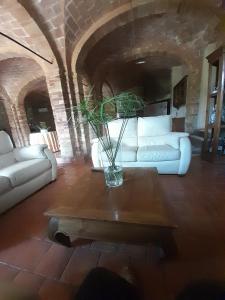 sala de estar con sofá blanco y mesa en Case Cordovani, en Magliano in Toscana