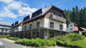 un ancien bâtiment avec un balcon dans une rue dans l'établissement Penzion Dominik, à Železná Ruda