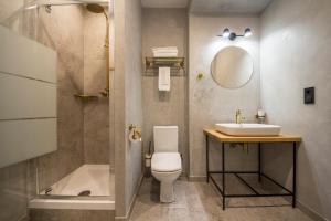 La salle de bains est pourvue de toilettes, d'un lavabo et d'une douche. dans l'établissement Idea Design Apart-Hotel Prorizna, à Kiev