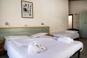 two beds in a hotel room with towels on them at Residence Nube D'Argento in Sestriere