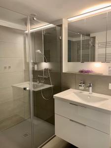 y baño con lavabo y ducha acristalada. en FeWo Prora - Designapartment Sir Henry, en Binz