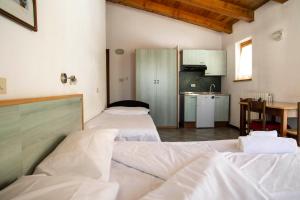 a room with three beds in it with a kitchen at Residence Nube D'Argento in Sestriere