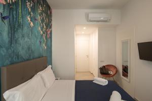 um quarto com uma cama e um quadro na parede em Relais Vittorio Veneto - Luxotel & Apartotel em Salerno