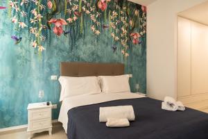 um quarto com uma cama grande e papel de parede floral em Relais Vittorio Veneto - Luxotel & Apartotel em Salerno