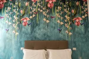 um quarto com uma parede com um mural de flores em Relais Vittorio Veneto - Luxotel & Apartotel em Salerno