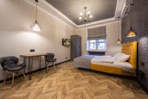 - une chambre avec un lit, une table et des chaises dans l'établissement Idea Design Apart-Hotel Prorizna, à Kiev