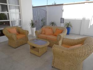 4 Korbstühle und ein Tisch auf einer Terrasse in der Unterkunft Casa Deco Hotel Boutique in Cochabamba