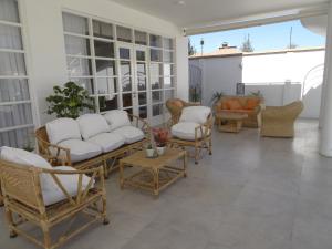 eine Terrasse mit weißen Möbeln und Stühlen auf einer Veranda in der Unterkunft Casa Deco Hotel Boutique in Cochabamba