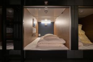 a room with two beds inside of a glass wall at NINJA & GEISHA in Osaka