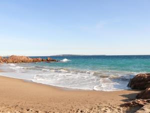 une plage de sable avec des rochers dans l'océan dans l'établissement Residhotel Villa Maupassant, à Cannes