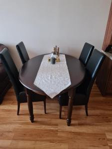 a black table with four chairs around it at Apartman 508 Residence in Donovaly