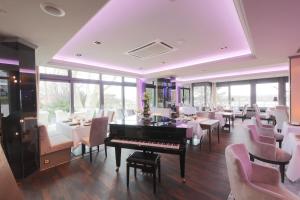 a restaurant with a piano and tables and chairs at FAVORITE Parkhotel in Mainz